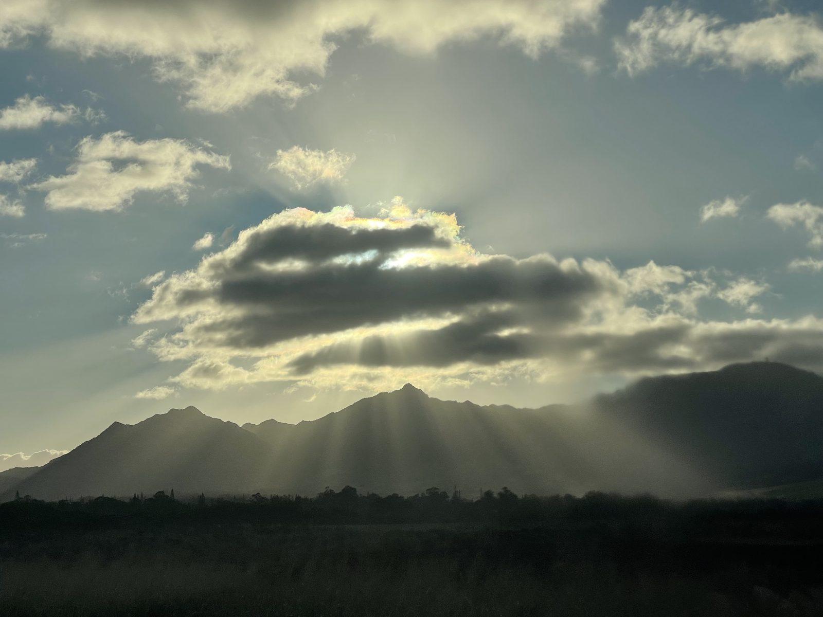 Sun rays breaking through clouds over the Wai'anae mountains