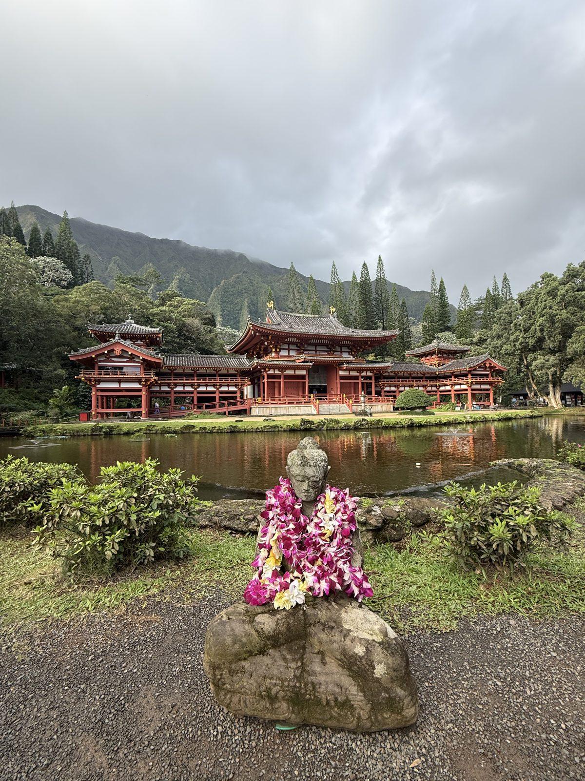 Lei-draped Buddha statue before the Byodo-In Temple